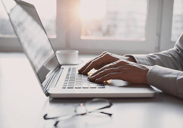 Close-up of male hands on laptop keyboard